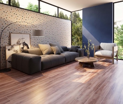 Sala moderna con sofá gris y pared azul, piso tipo madera y decoración minimalista con luz natural y estilo acogedor.
